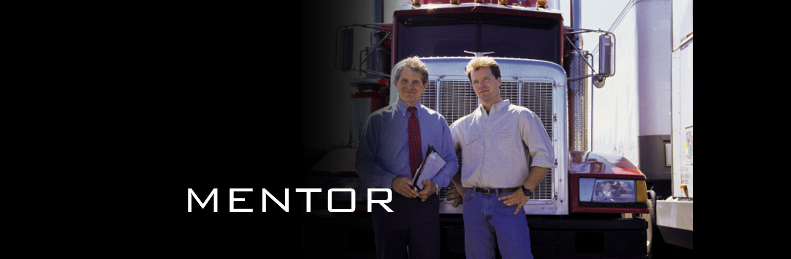 Image of two men standing in front of a truck.